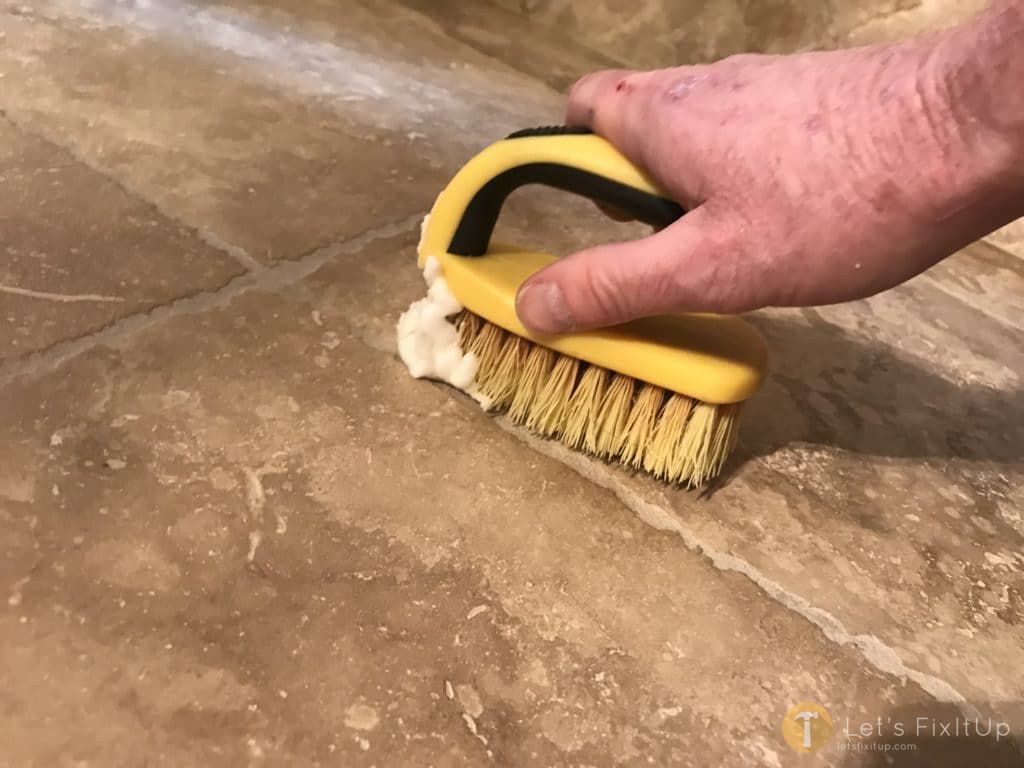 scrubbing grout with baking soda paste