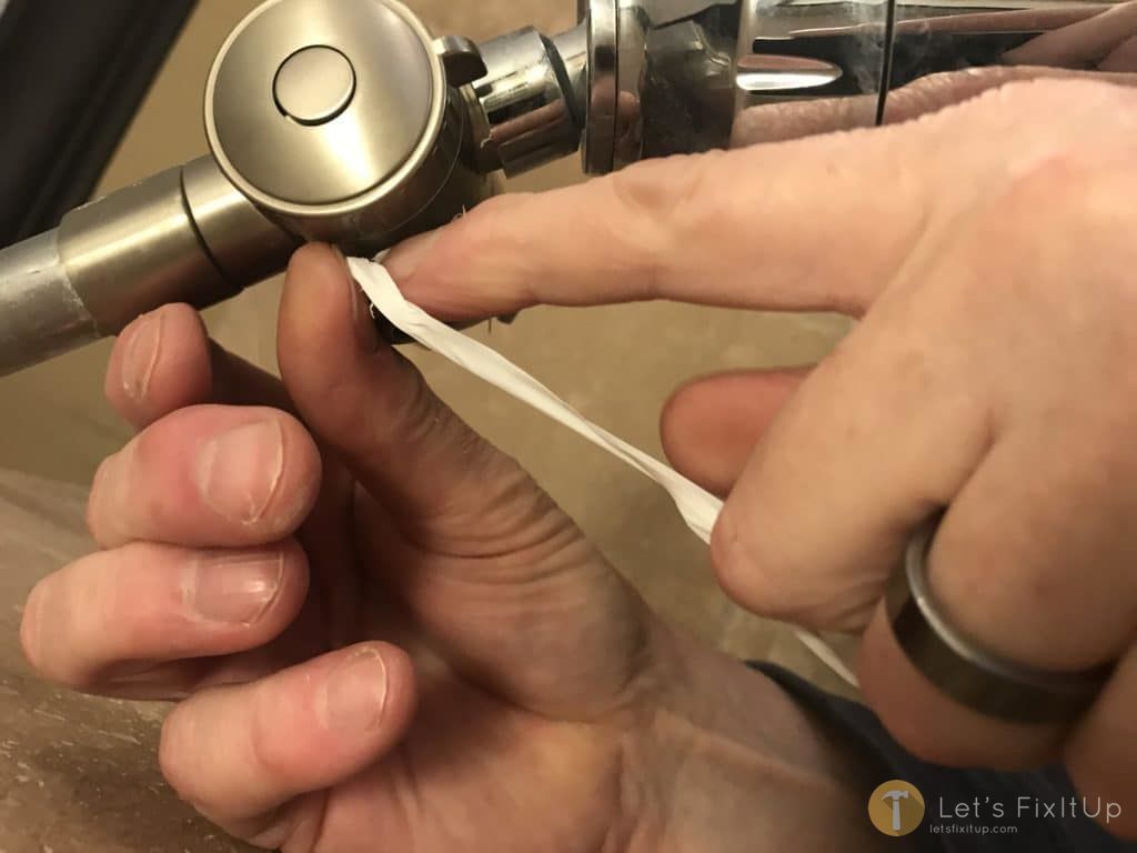 applying plumbers tape to threads